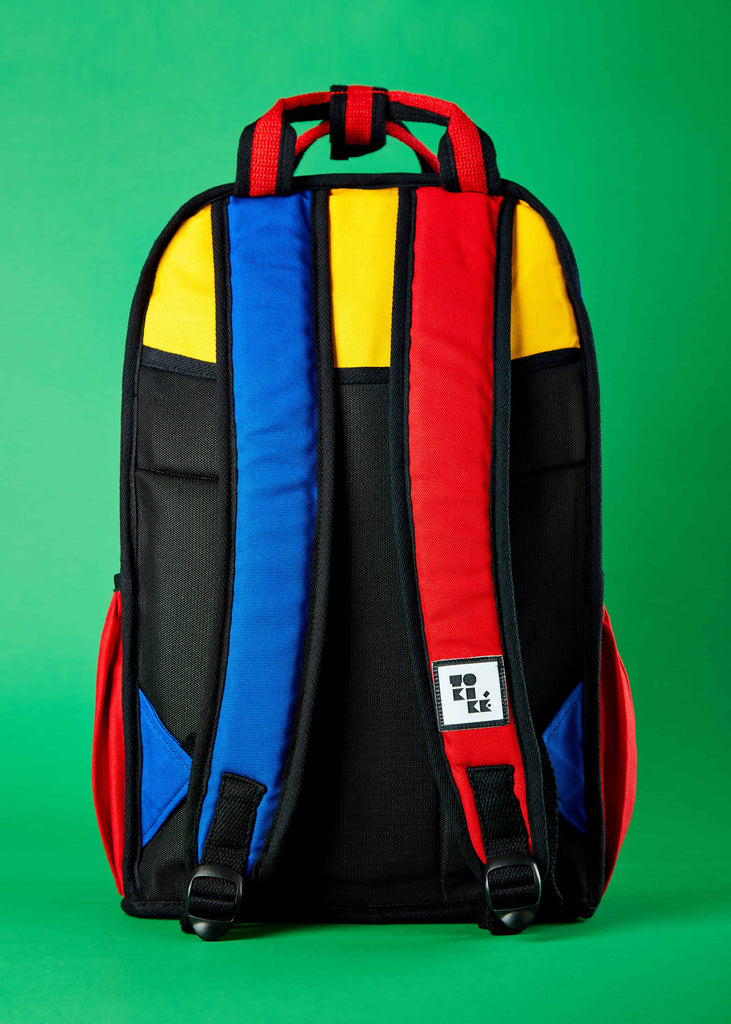 Pieter Travel Backpack - Convenient and Stylish Carry"  A lifestyle shot highlighting the Pieter travel backpack in use, offering convenient and stylish carrying options. The Piet Mondrian colorblock art adds an artistic touch to this versatile travel companion.