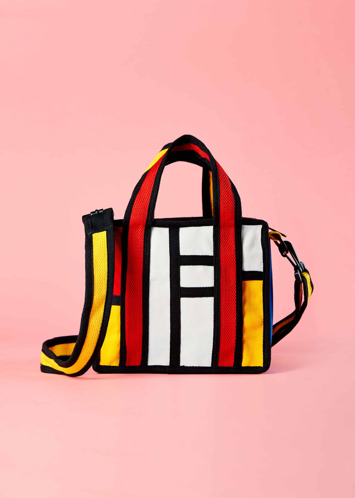 Fashionable and Functional Accessory" Alt text: "A lifestyle shot showcasing the Floris sling bag in use, complementing various outfits with its Piet Mondrian-inspired colorblock design. This fashionable and functional accessory adds a unique artistic flair to any ensemble
