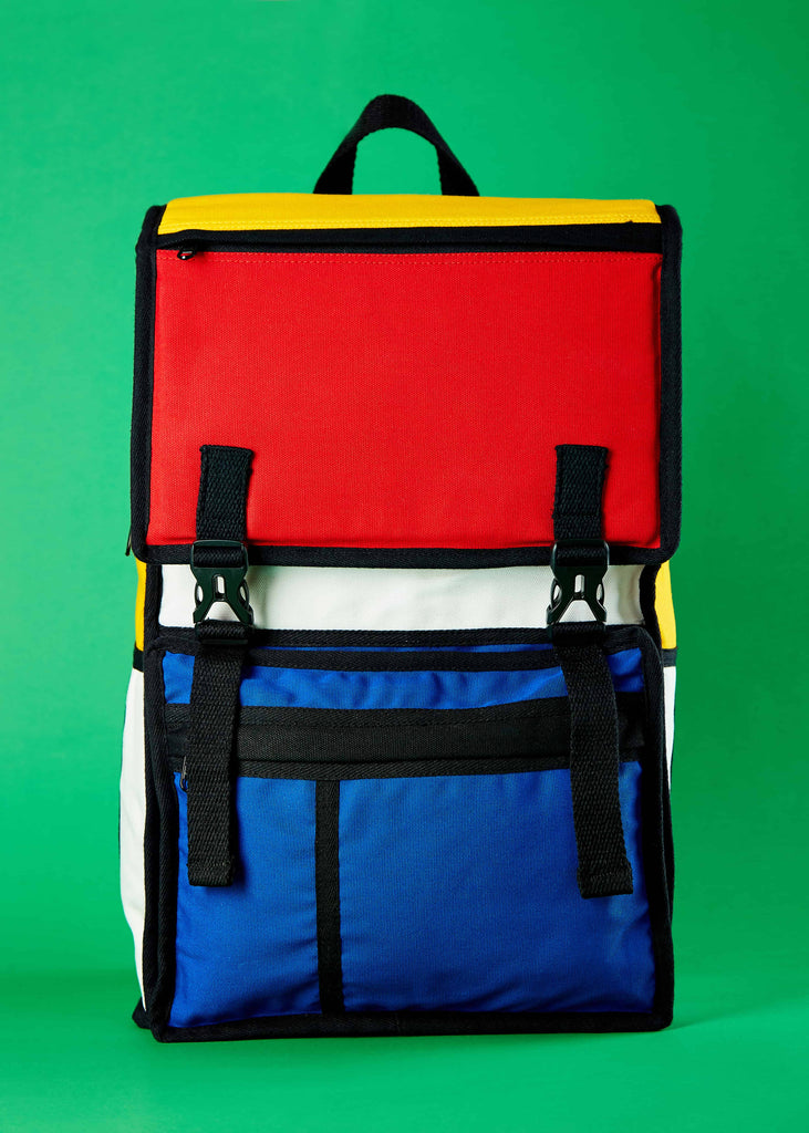 Reizen Designer Travel Backpack - Piet Mondrian Colorblock Art"     Front view of the Reizen designer travel backpack, featuring a striking Piet Mondrian-inspired colorblock art design. This canvas backpack is thoughtfully crafted for 3-day trips with family and friends, combining style and functionality.