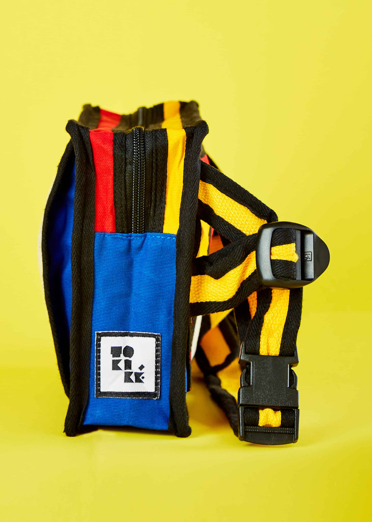 Top-down view of the Aizik Crossbody Bag, an exquisite accessory meticulously crafted from cotton canvas, drawing inspiration from Piet Mondrian's Colorblock art. The bag presents a captivating arrangement of bold color blocks, offering a unique and visually captivating design