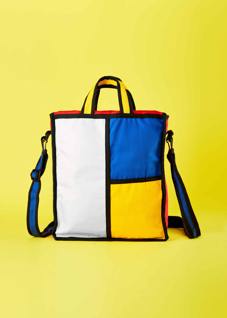 Godewyn Expandable Tote Bag - Elevate Your Style with Artistic Sophistication.  A lifestyle shot showcasing the Godewyn expandable tote bag, an embodiment of artistic sophistication. The Piet Mondrian-inspired colorblock pattern adds a unique touch to your ensemble, elevating your style to new heights
